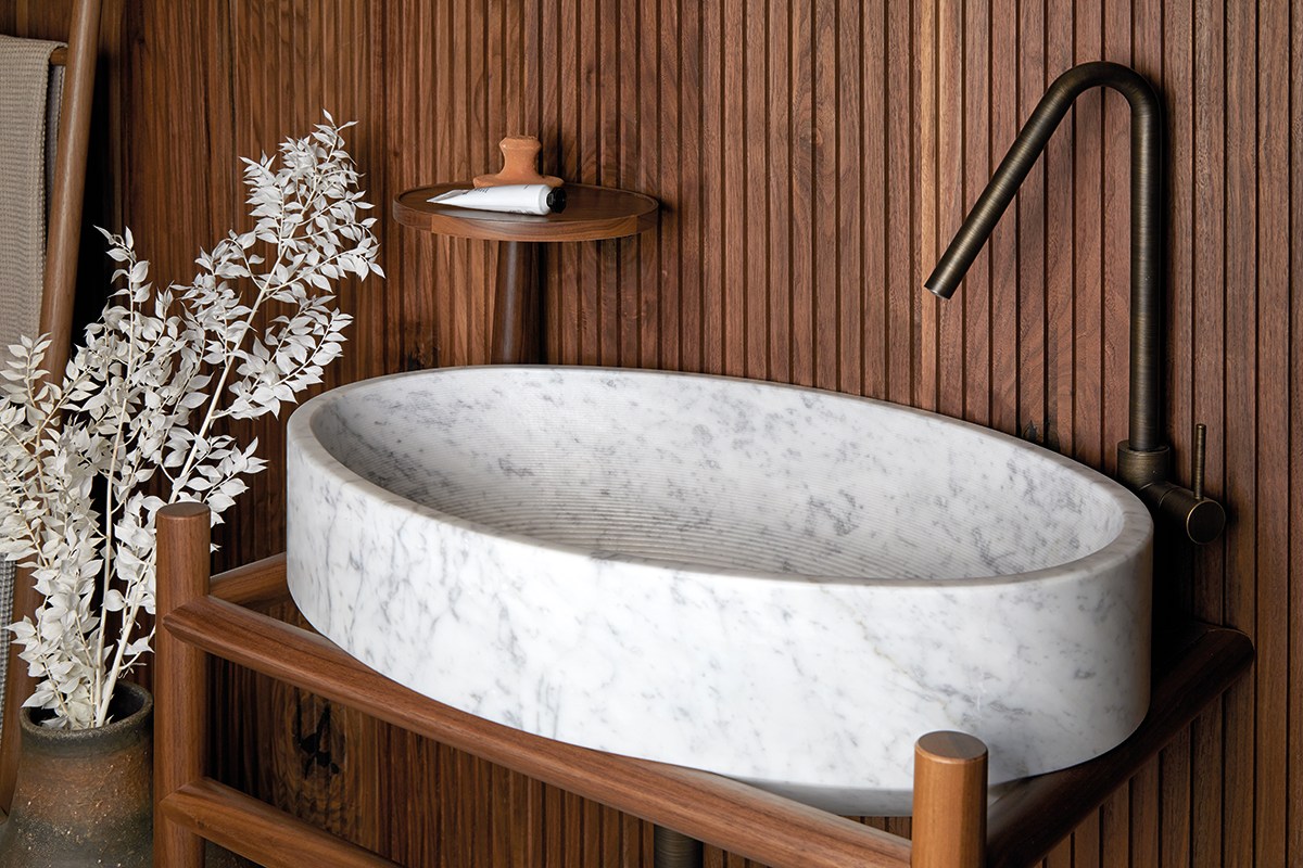 marble basin with wood panelling on the wall