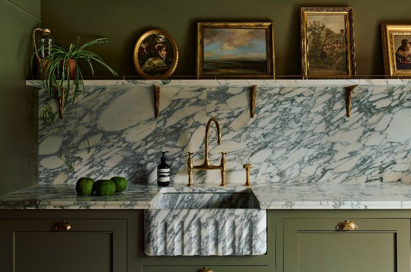dark green kitchen with marble surfaces and brass accents