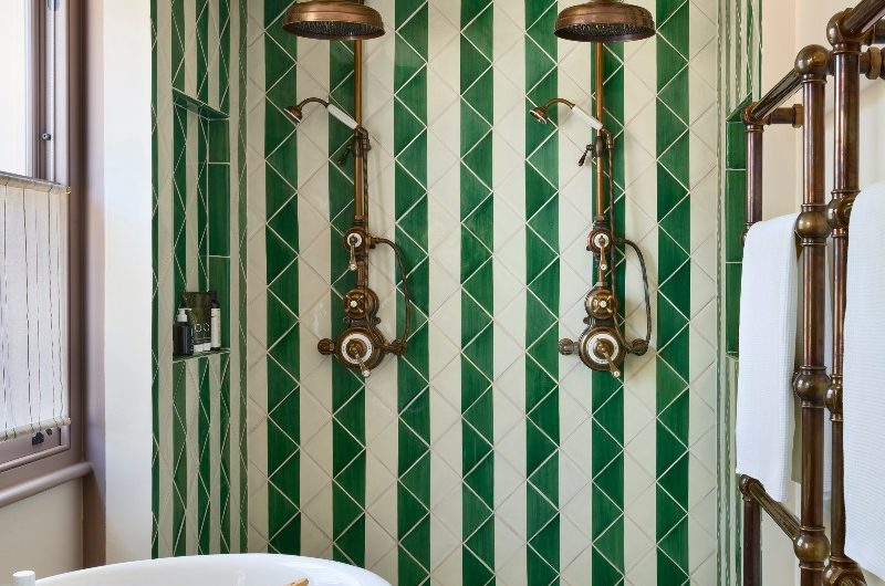 tiled walk-in shower with bronze brassware