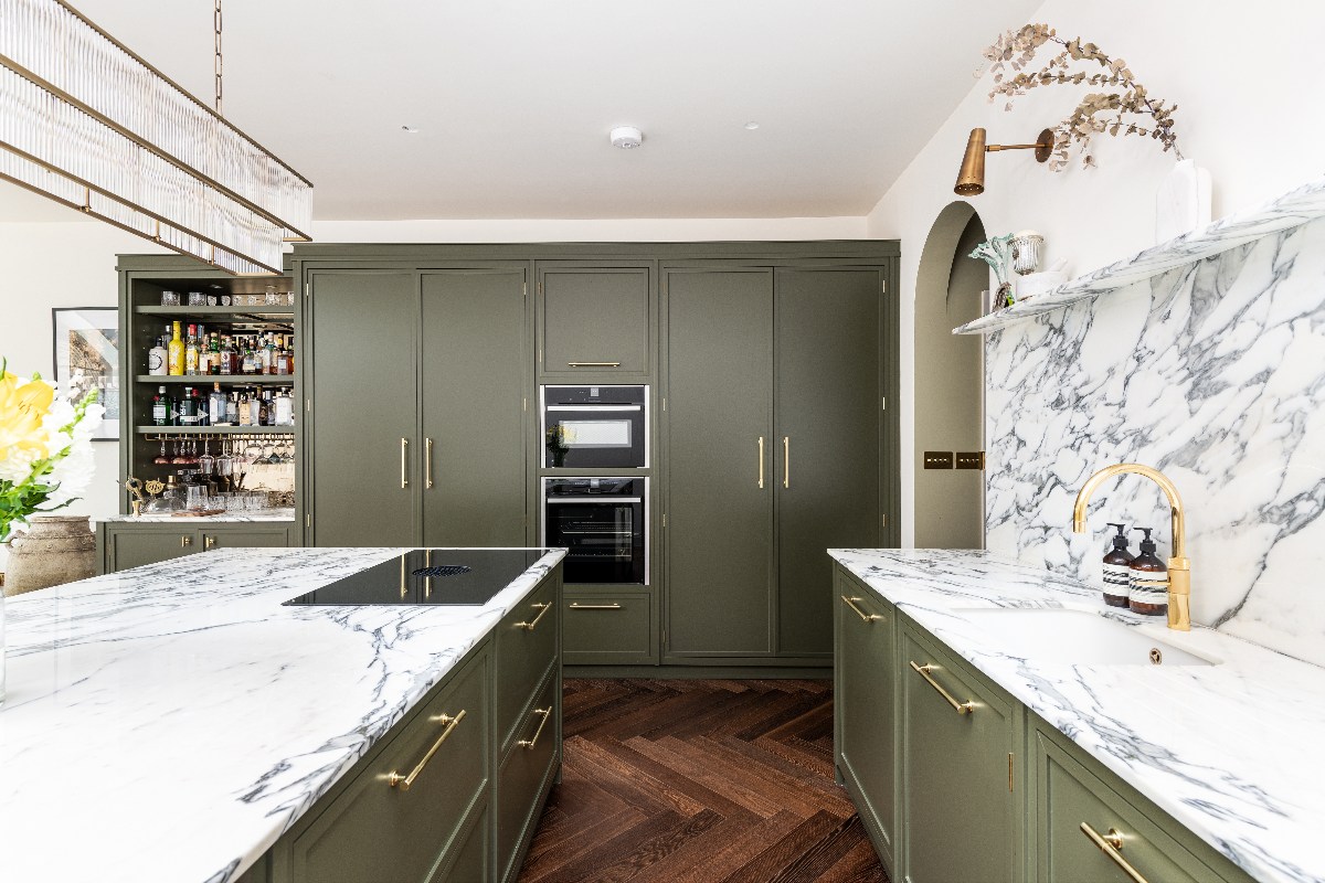 dark green kitchen design with marble worktops and splashbacks