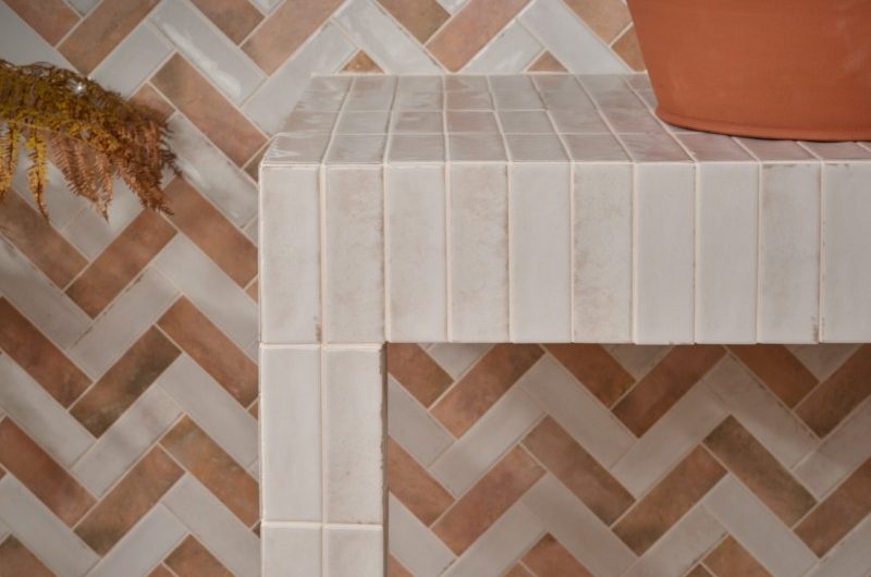terracotta tiles on bathroom walls and floor, and a terracotta countertop basin